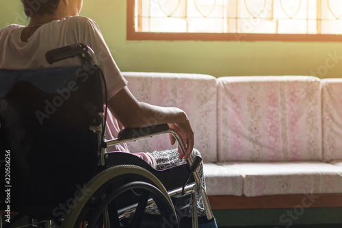 Asian senior or elderly old lady woman patient on wheelchair looking out the window so sad at home,healthy strong medical concept