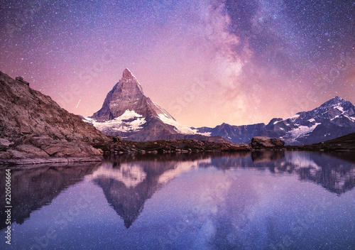 Matterhorn and reflection on the water surface at the night time. Milky way above Matterhorn, Switzerland. Beautiful natural landscape in the Switzerland