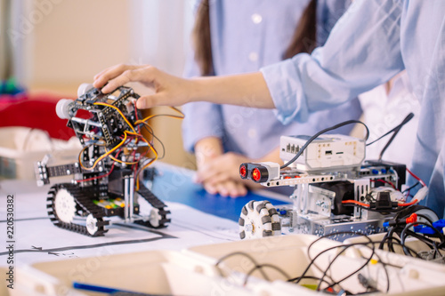 Close up of construction workflow of electronic car with microcontroller at junior robotics club. Collective child s creation of diy electronics, modern technologies, innovation and science concept