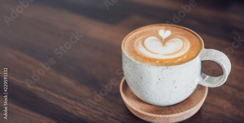 hot cappuccino coffee cup on wooden tray with latte art on wood table at cafe.food and drink concept.leave copy space for adding text.