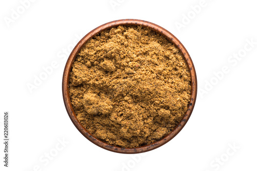ground nutmeg powder spice in wooden bowl, isolated on white background. Seasoning top view