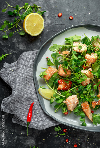 Fresh Salmon salad in asian style with sesame seeds, chili, lemon and green vegetables