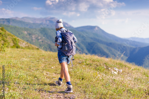 Young woman hiking in the forest in the summer. Hiking concept in the mountain
