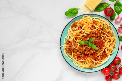 pasta spaghetti bolognese on a blue plate on white marble table. healthy food. view from above
