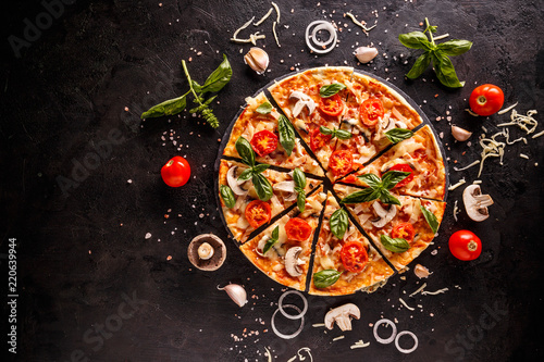 Tasty pizza with cherries, onions and mushrooms on a black background