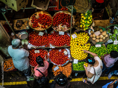 people buying food, fruit and vegetables at a stall in traditional central market in Port Louis, Mauritius