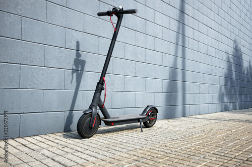 electric scooter near blue concrete wall