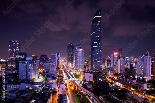 night of urban cityscape in metropolis and light of sky train