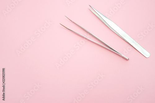 tools for Eyelash Extension Procedure. Two tweezers on pink background. copyspace mockup - Beauty and fashion concept