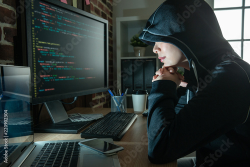 female hacker staring at the screen smiling.