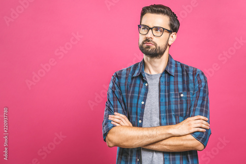 Young man with emotions on his face with a beard on a pink background, logo, copy space.