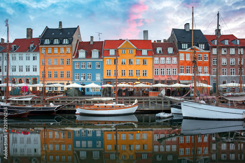 Nyhavn at sunrise, with colorful facades of old houses and old ships in the Old Town of Copenhagen, capital of Denmark.