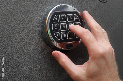 Hand enters combination on digital lock on a safe