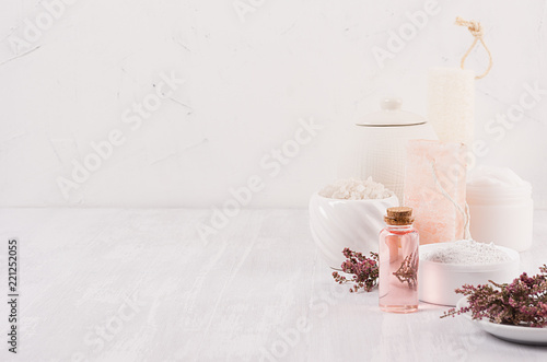 White and pink delicate cosmetics products for body and skin care in white modern bathroom on shelf, copy space.