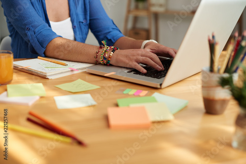 Teacher working on laptop when preparing for class at her table