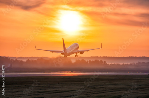 Scenic dawn with a fog at the airport. Takeoff of a passenger airplane