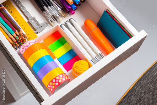 Opened office desk drawer with stationary