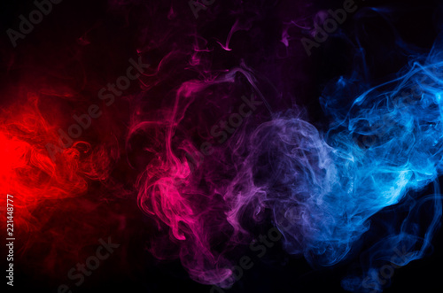 abstract shapes of mixed colors of blue and red smoke at dark background