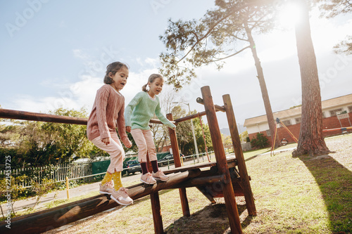 Cute little girls having fun on outdoor playground