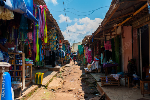 view of colorful open air street market in doula cameroun during sunny day with traditional clothes