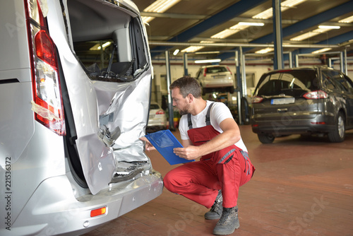 Begutachtung eines Unfallschadens in der Autowerkstatt durch Mechaniker/ Sachverständiger für Versicherung nach Autounfall // Expert opinion on accident damage in the car repair shop