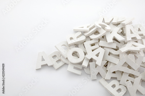 Pile of white painted wooden letters. Typography background composition.