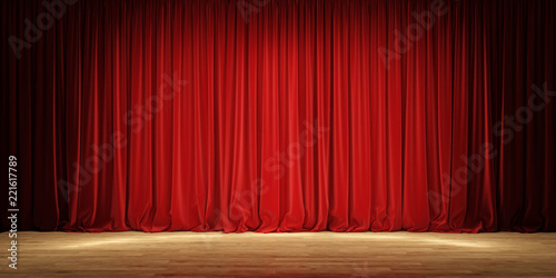 Empty theater stage with red velvet curtains.