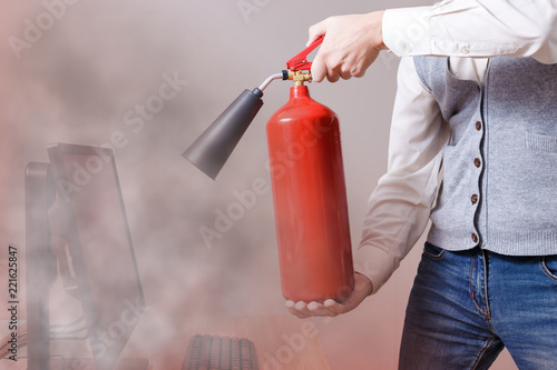 Man using fire extinguisher to stop fire in the apartment. Concept of protection and security 