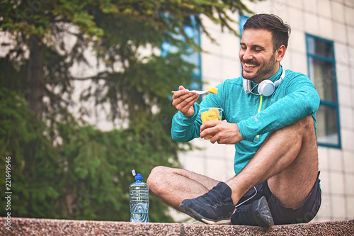 Man is eating fruit after morning workout