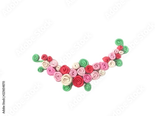 Beautiful different color rose made from plasticine clay on white background, decoration curve shape red pink white floral dough, cute vintage style