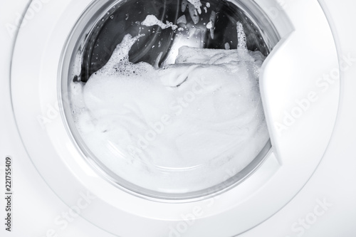 Process of cleaning white cloth in washing machine, stainless drum inside with wet towels,