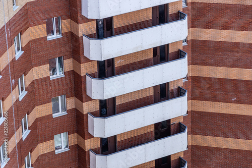 White balconies on the building of red brick