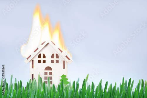 Safety fire concept. Toy house with flames. Burning model house.
