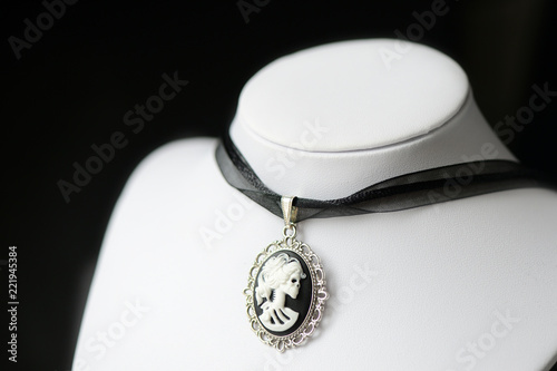 Halloween necklace with skeleton cameo pendant on a dark background close up