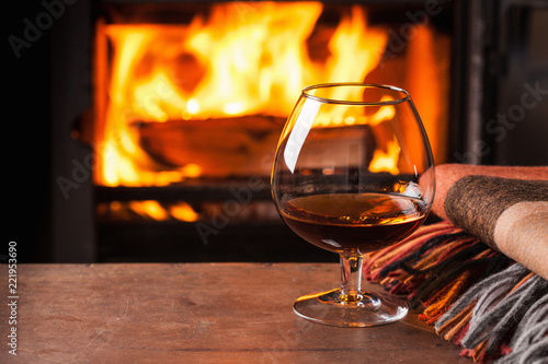 a glass of cognac in front of fireplace