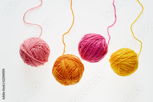 Collection of colorful woolen balls, partially unrolled.