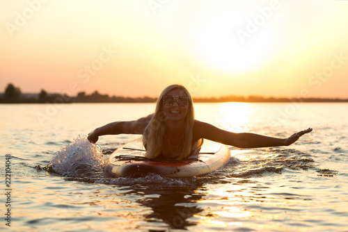 Young sexy woman swimming on paddle board.Water sports , active lifestyle. 