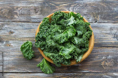 Fresh green curly kale leaves on a wooden table. selective focus. rustic style. healthy vegetarian food