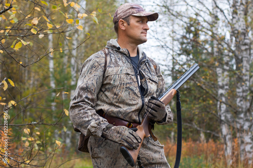 hunter with gun in the birch forest