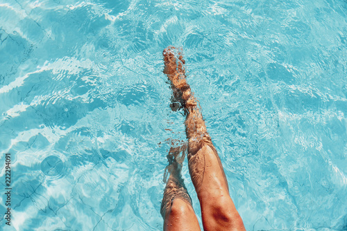 beautiful woman legs splashing in the pool