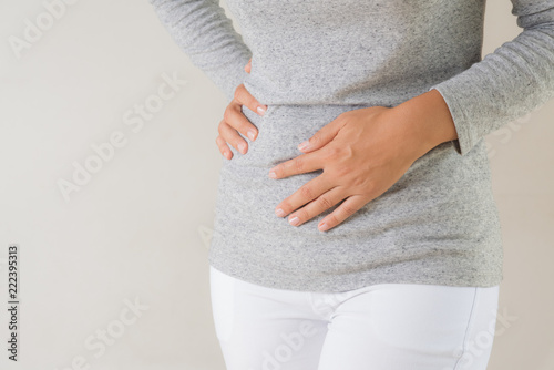 Young woman having painful stomachache. Chronic gastritis. Abdomen bloating concept.