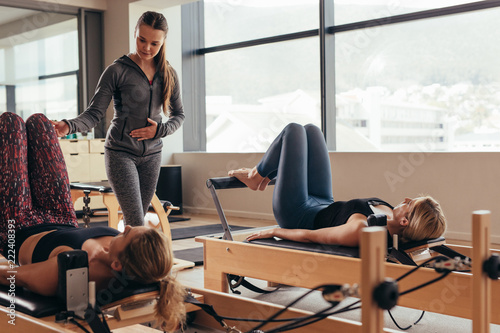 Pilates instructor training women at the gym