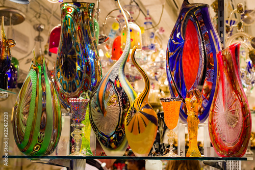 Bright, colorful Murano glass vases and glassware on display in Venice shop window.