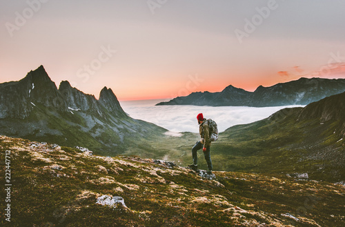 Man backpacker hiking in mountains alone outdoor active lifestyle travel adventure vacations sunset Norway landscape
