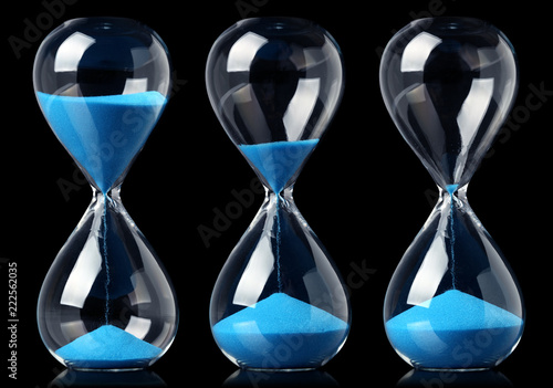 Collection of hourglasses with blue sand showing the passage of time