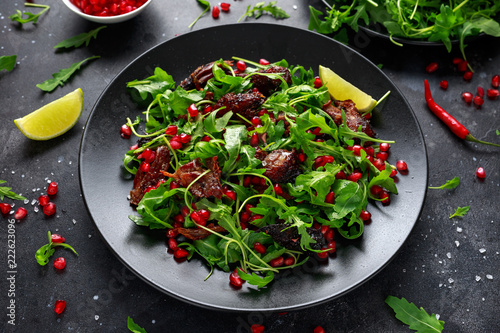 Spicy crispy duck salad with pomegranate seeds, lime and wild green rucola