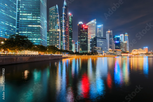 Singapore city skyline. Business district view. Downtown reflected in water at night in Marina Bay. Travel cityscape