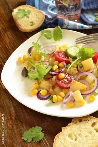 Salad with corn, fresh vegetables and baked potatoes, vertical