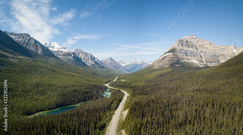 Aerial panoramic landscape view of a scenic road in the Canadian Rockies during a vibrant sunny summer day. Taken in Banff Windermere Parkway, Alberta, Canada.