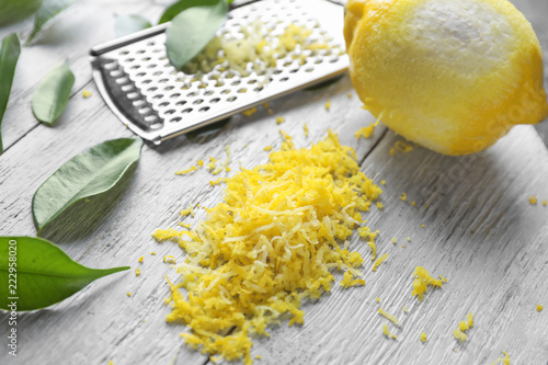 Peeled ripe lemon with zest on wooden background